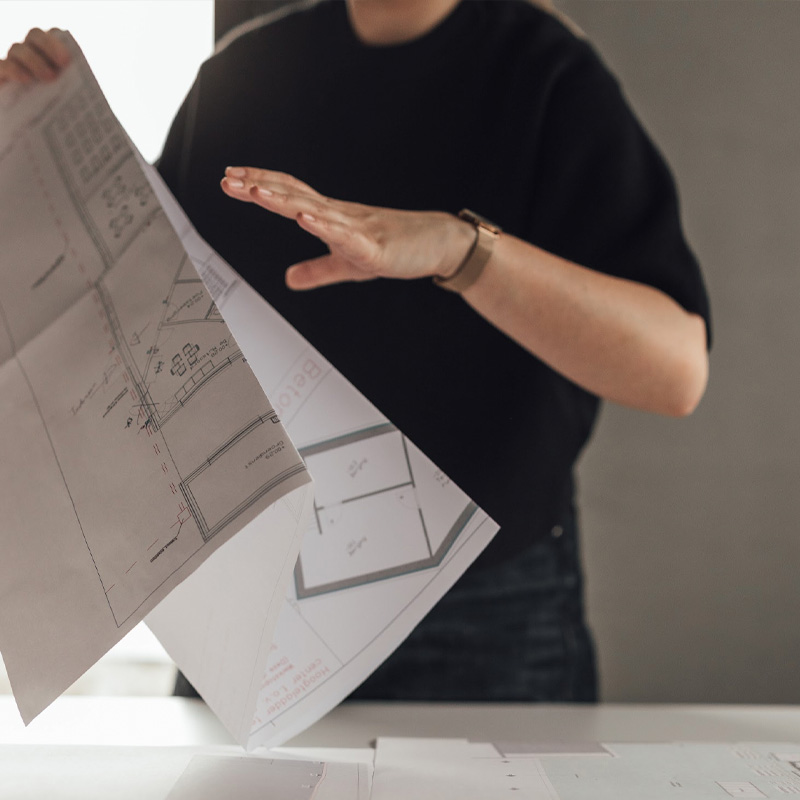 Bouwplannen worden gecontroleerd ter voorbereiding van de uitvoering van een vastgoedproject